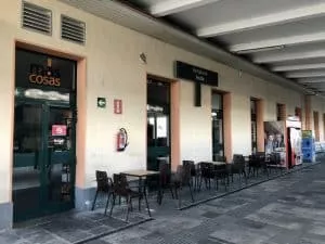 Mesas y sillas de la única cafetería de la estación con entrada por varios sitios.